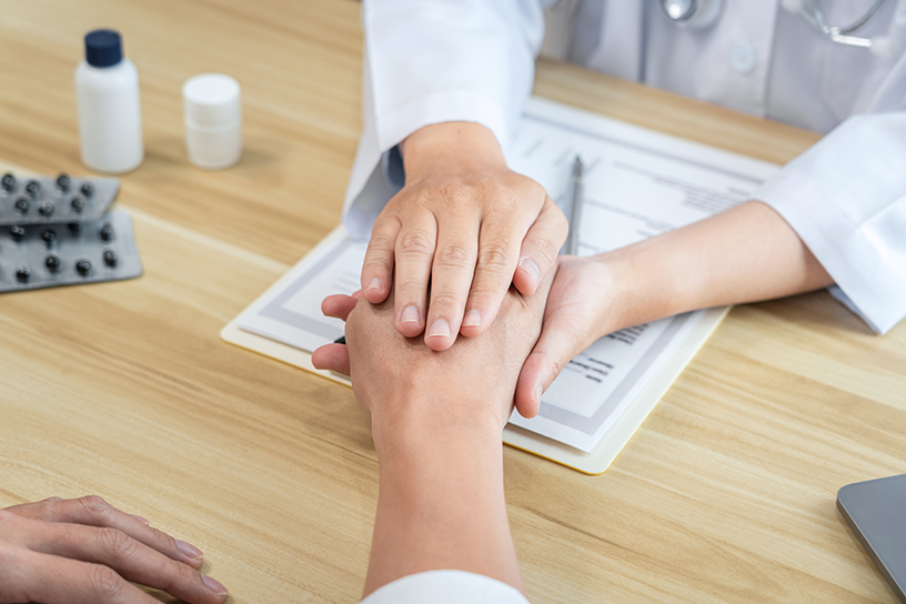 Doctor touching patient hands for encouragement and empathy on the hospital, cheering and supporting patient, medical examination, trust and ethics.